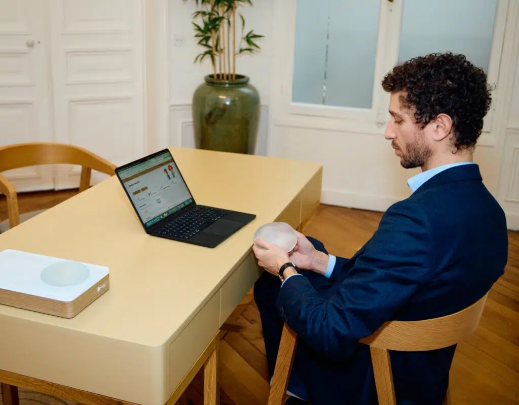 Dr barbera assis dans son bureau tenant un implant mammaire parcours patient | Dr Barbera Paris
