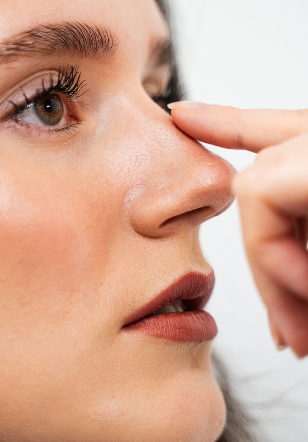 Visage d une jeune femme avec un doigt du docteur poser sur son nez Rhinoplastie medicale | Dr Barbera Paris